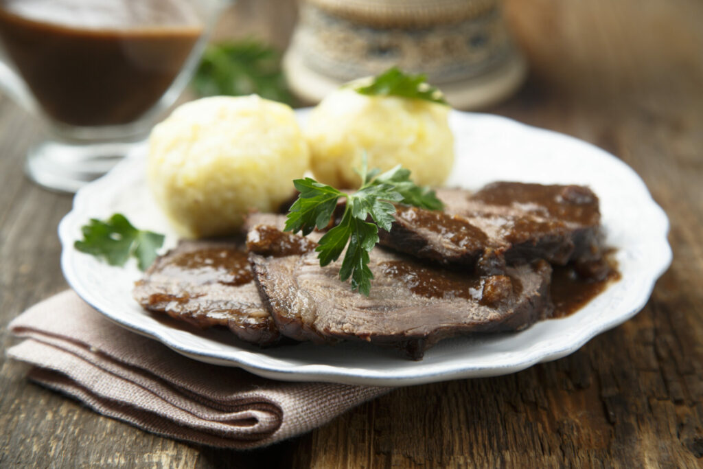 Baked meat or Sauerbraten with spicy sauce and potato dumplings