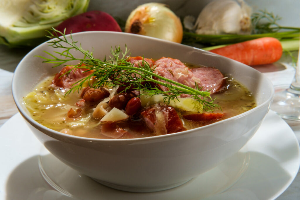 German kielbasa Oktoberfest stew with cabbage potatoes and a glass of white wine