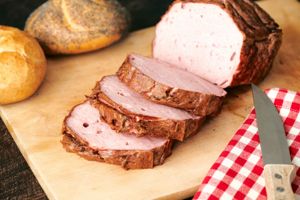 Liver cheese in a bread roll on wooden table top to eat in the Hadn