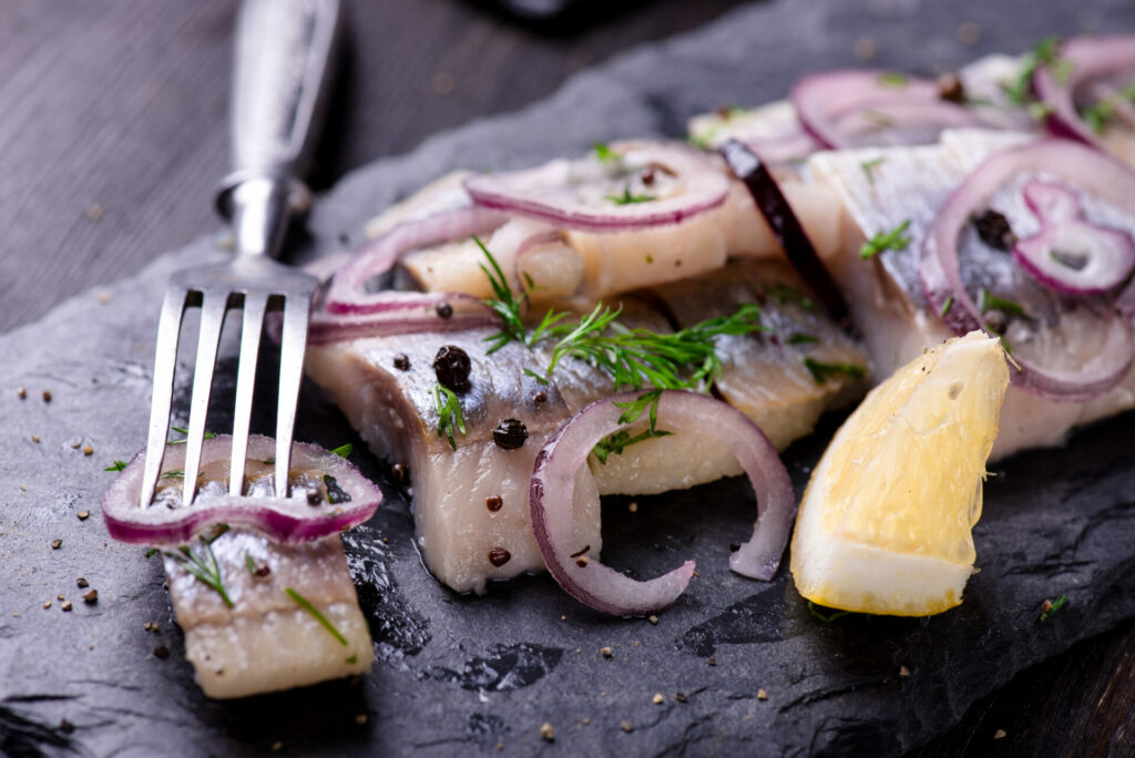 Sliced herring salad on a black slate plate