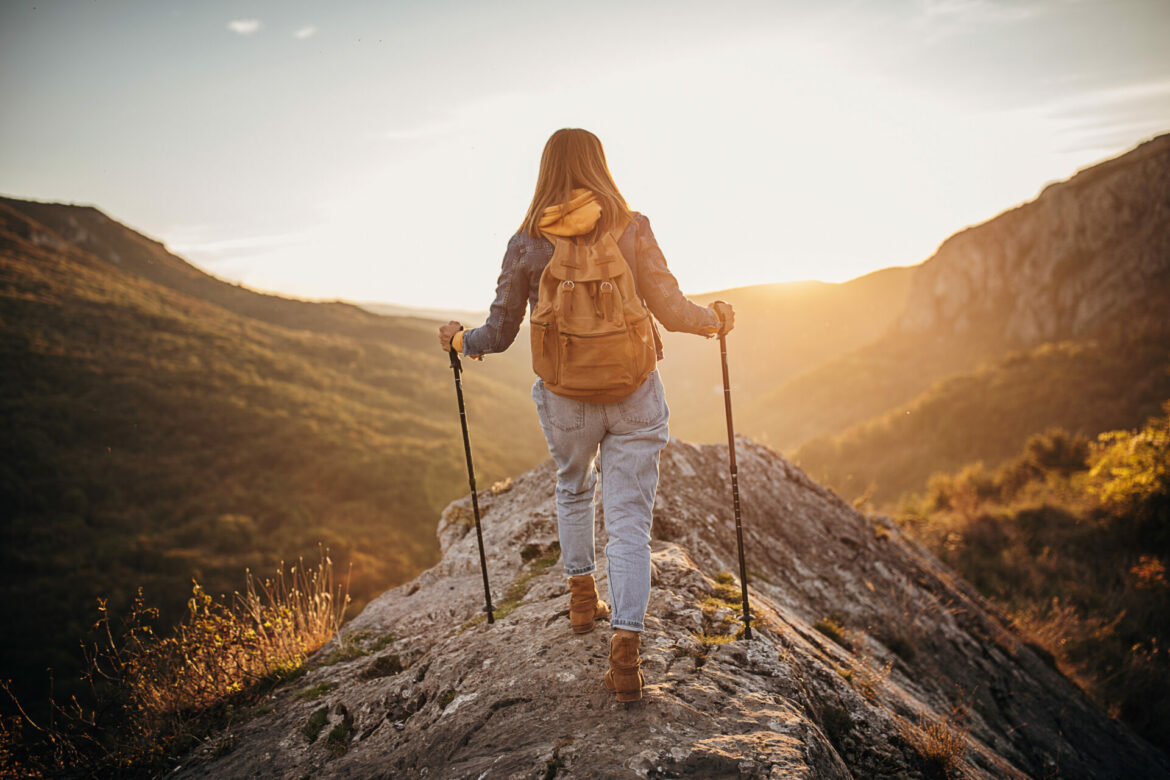One woman, female hiker hiking alone on mountain, sunny autumn day.