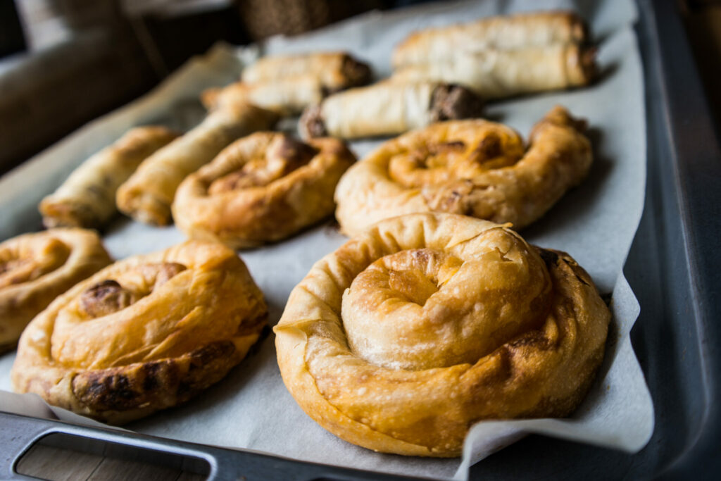 strifti pita borek with cheese, spinach or leek on a tray.